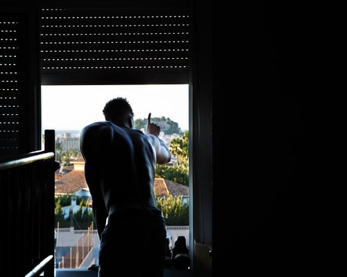 Person adjusting blinds to control the natural sunlight entering the room
