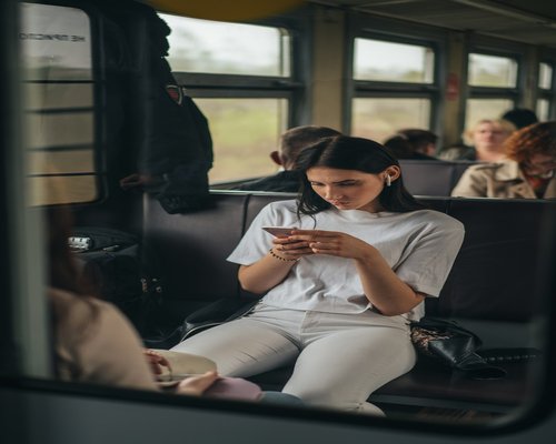 Person commuting on a bus while checking their phone safely